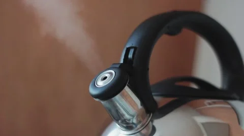 Kettle boiling on kitchen stove. Hot steam rises from the whistle Stock Footage 48838388