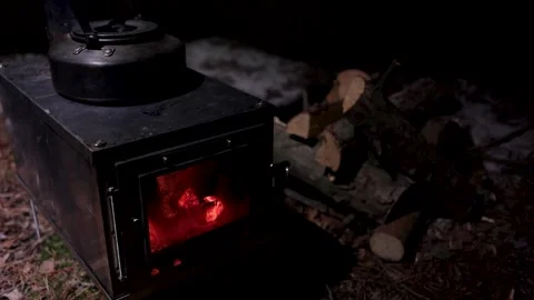 Kettle boiling on a titanium stove, burning wood, dark time of day Stock Footage 211689537