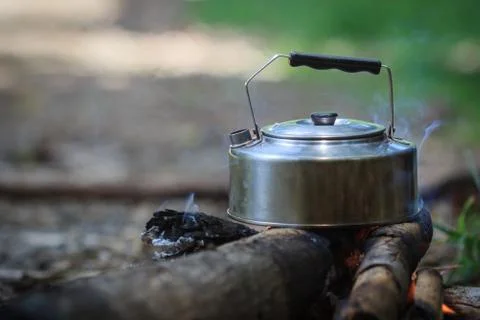 The kettle boils on campfires Stock Photos