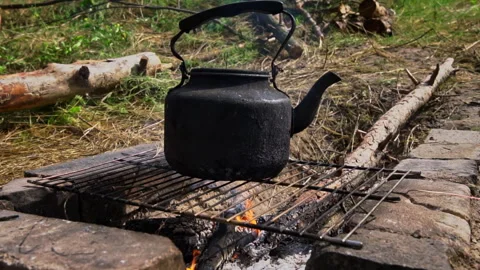 Kettle Boils on an Open Fire During the Day Stock Footage 250240690