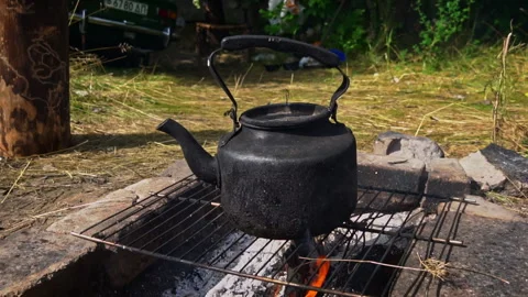 Kettle Boils on an Open Fire During the Day Stock Footage 252806168