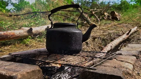 Kettle Boils on an Open Fire During the Day Stock Footage 252806387