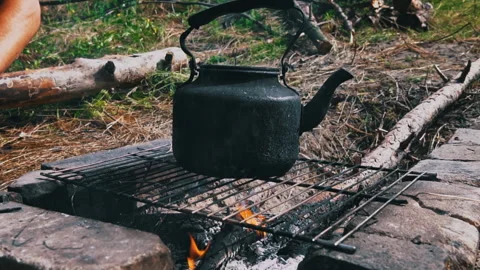 Kettle Boils on an Open Fire During the Day Stock Footage 252807976