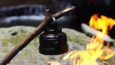 Kettle on a Campfire with a Small Mountain Stream in the Background Video stock 313353606