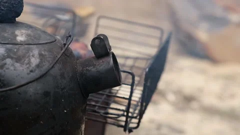 Kettle on the fire in the campaign. Tea party on hike. A soot-black kettle of Stock Footage 230721388