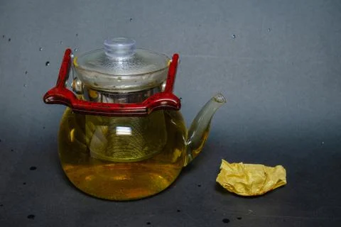 A kettle next to pressed green tea with mint. Stock Photos