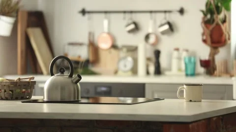 Kettle is on the stove and a cup is on a table Stock Footage 135603563