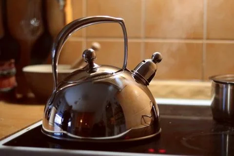 Kettle, on the stovepot in the kitchen Stock Photos