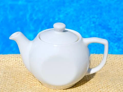 Kettle with tea on the background of the pool. Refreshing herbal tea. Stock Photos