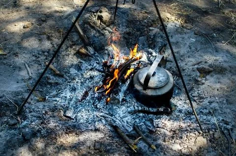 Kettle on a tripod over the fire Stock Photos