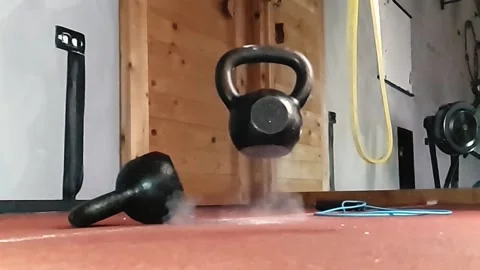A kettlebell falling and bouncing back from a rubber floor. Superslowmotion 스톡 동영상 143185314