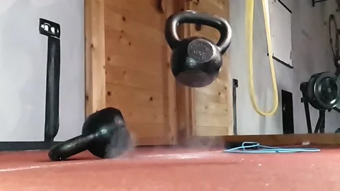 A kettlebell falling and bouncing back from a rubber floor. Superslowmotion Stock Footage 143185552
