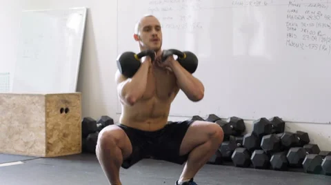 Kettlebell squat exercise - young man doing weights workout at gym Stock Footage 65280037