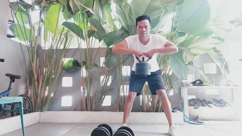 Kettlebell workout routine, Man training with weights at home Stock Footage 306212010