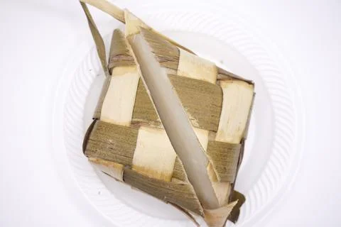 A ketupat split in half on a plastic plate, photo taken from above Stock Photos