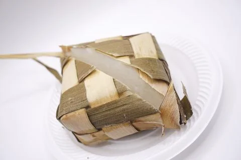 A ketupat that is split in half on a plastic plate, photo taken from the side Stock Photos