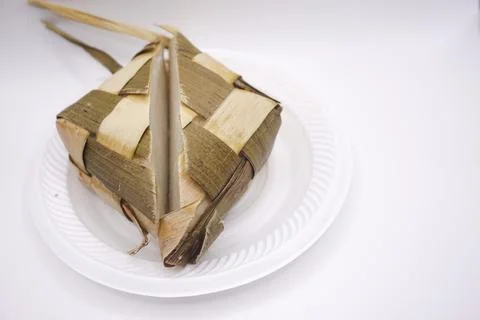 A ketupat that is split in half on a plastic plate, photo taken from the side Stock Photos