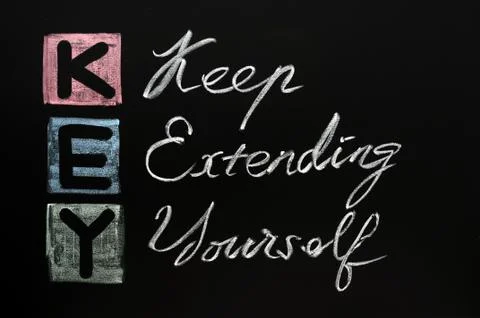 Key acronym -keep extending yourself on a blackboard with words written in ch Stock Photos