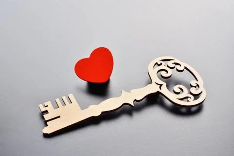 Key and heart on grey background Stock Photos