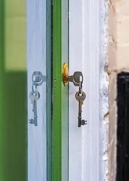 Key and reflection in the front door of a house with others hanging from ke.. Stock Photos