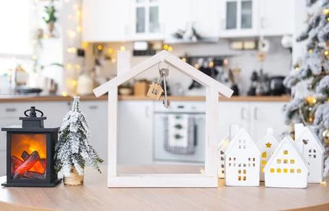 Key and tiny house of a small size on cozy home with Christmas decor on ta... Stock Photos