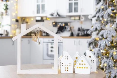 Key and tiny house of a small size on cozy home with Christmas decor on table of Foto stock
