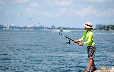 Key Biscayne, Florida, U.S - September 20, 2024 - A young boy fishing near .. Stock Photos