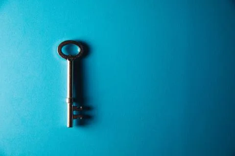 Key on blue background. Minimal creative style Stock Photos