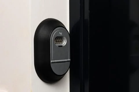 Key box with a combination lock next to the door and a bell button on the wal Stock Photos