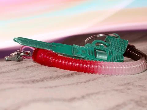 Key chain gun shape presented on light effect background. Stock Photos