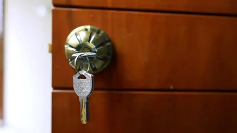Key in Door Lock Close-Up, Close-up of a key in a door lock on a wooden door Stock Footage 317131588