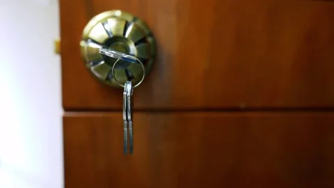 Key in Door Lock Close-Up, Close-up of a key in a door lock on a wooden door Stock Footage 317131602