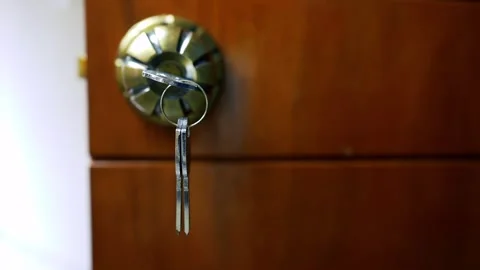 Key in Door Lock Close-Up, Close-up of a key in a door lock on a wooden door Stock Footage 317131614