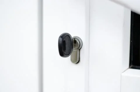 The key is in the door lock of the white front door Stock Photos