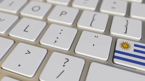 Key with flag of Uruguay on the computer keyboard switches to key with flag of Stock Footage 110763402