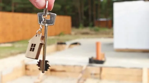 Key of home in hand before a construction site Stock Footage 153456826