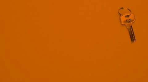 A key from home on orange background. Stock Photos
