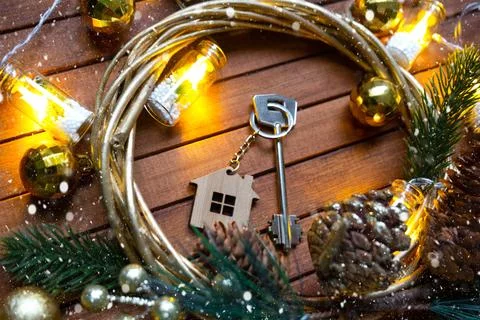 Key to house with a keychain tiny home on wooden background with Christmas .. Stock-Fotos