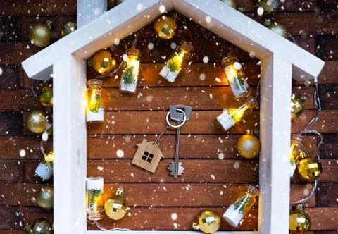 Key to house with a keychain tiny home on wooden background with Christmas .. Stockfoto's