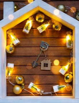 Key to house with a keychain tiny home on wooden background with Christmas .. Foto stock
