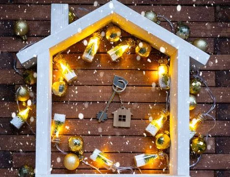 Key to house with a keychain tiny home on wooden background with Christmas... Foto stock