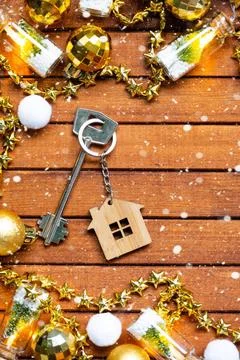 Key to house with a keychain tiny home on wooden background with Christmas... Foto stock
