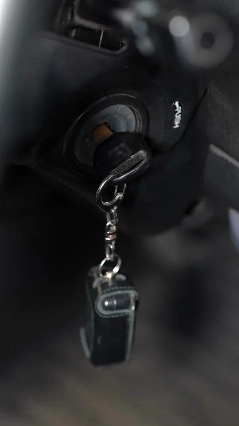 Key Inserted into Ignition Lock During Vehicle Start-Up Process in Auto Workshop Stock Footage 346338028