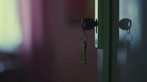 Key is inserted into the lock of the door, indoors, the light from the window Video stock 195331619
