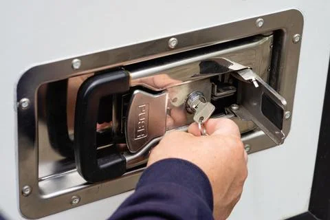 Key inserting into metal storage box lock photo Foto stock