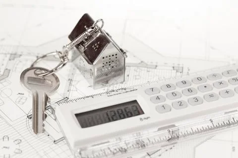 Key with keychain in the form of a silver-colored house on a background of ar Stock Photos
