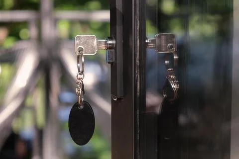 Key with a large oval keychain is inserted into the keyhole Stock Photos