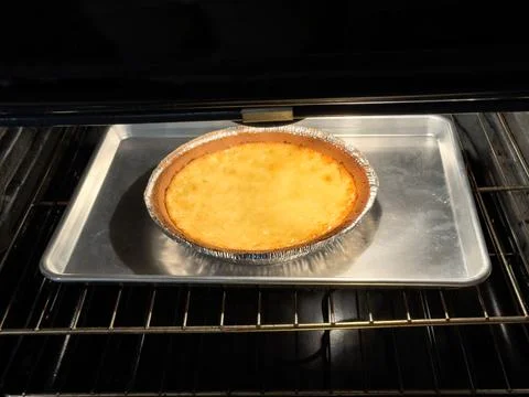 Key lime pie being baked in electric oven for dessert Stock Photos