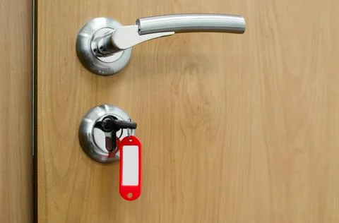 Key in a lock with an empty tag. The concept of buying, selling new housing. Stock Photos