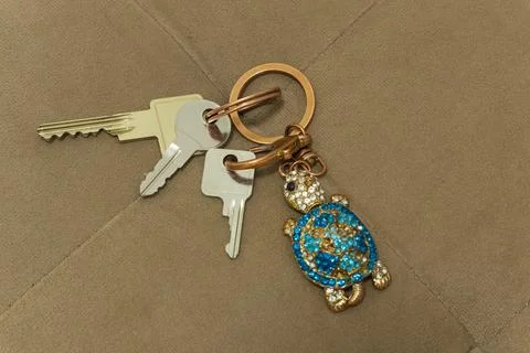 Key ring with earrings on the background of a upholstered furniture Stock Photos
